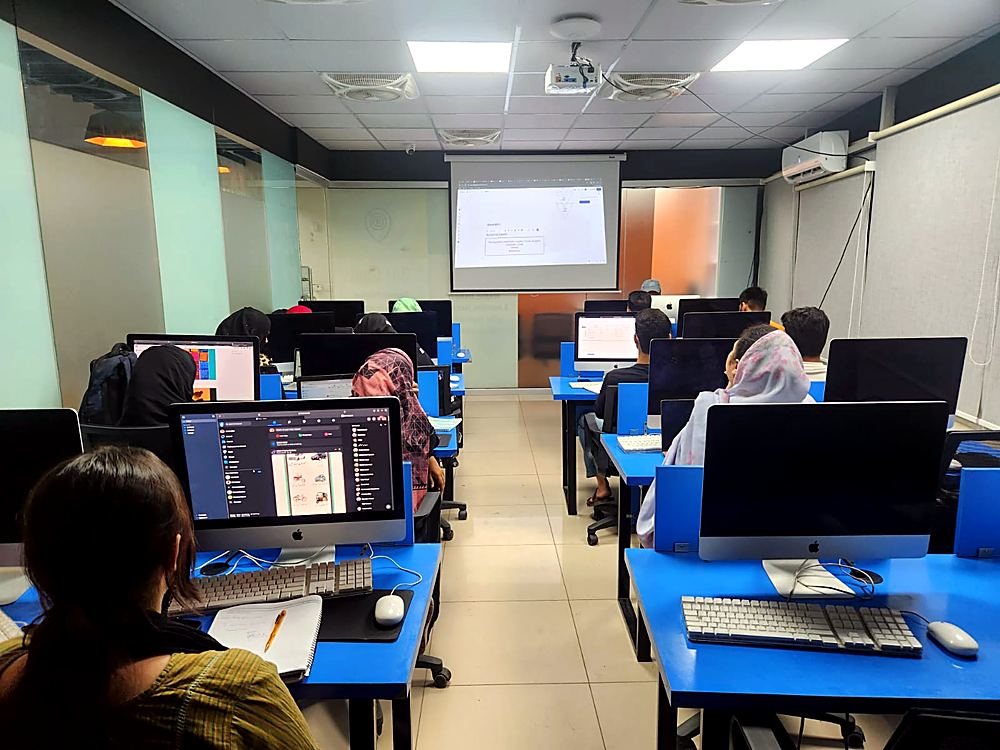 Learners following a lesson on the projector in a BBT lab